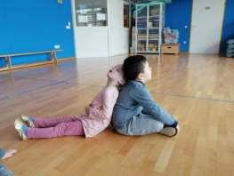 DVA KOT EDEN Otroci se po dva in dva usedejo in se s hrbti med seboj dotikajo.