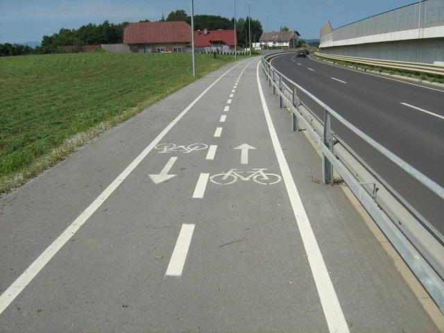 V naselju je steza za kolesarje od vozišča za motorna vozila ločena z robnikom in varovalno širino.