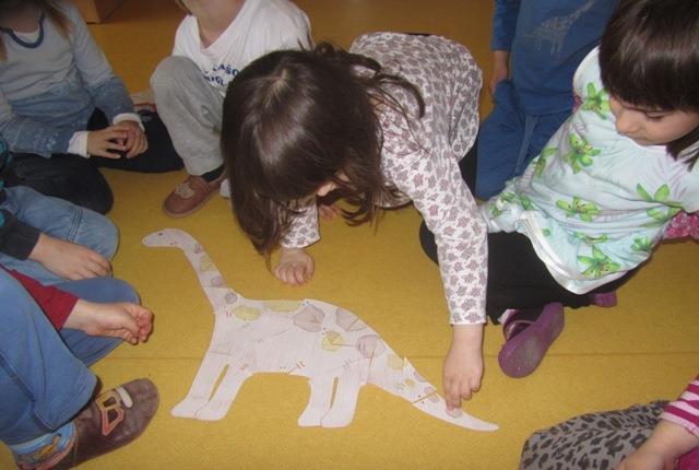 Slika 1: Sestavljanje dinozavra 9 IZDELOVANJE DINOZAVRA NOGAVIČKE Cilji: otrok razvija čutne zaznave (tip) in uživa pri polnjenju dinozavrov iz odpadnega materiala; otrok rešuje probleme, ki se mu