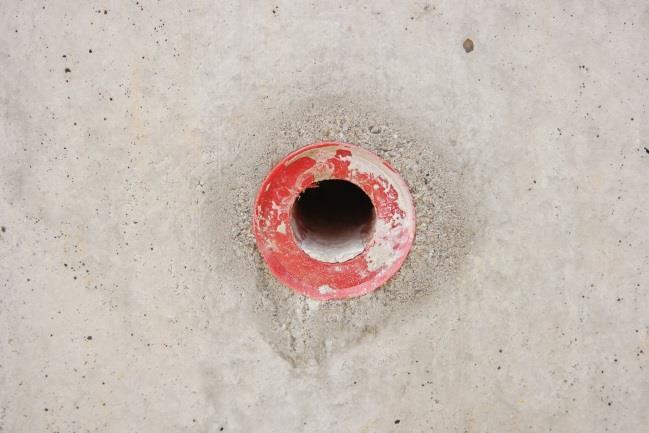 Izvedba vidnega betona Stran 95 Nastale pa so tudi nekatere napake, kot so iztekanje cementnega mleka v okolici plastičnih konusov
