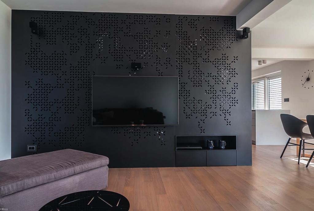 MARKANTNA perforirana stena iz lakiranega črnega mediapana je v središču pozornosti in daje bivalnim prostorom eleganten značaj.
