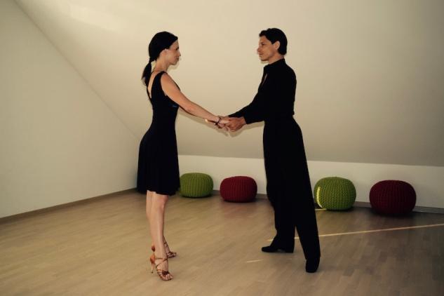 Odprta drža z obema rokama, kjer si plesalca stojita nasproti in se držita za roki.